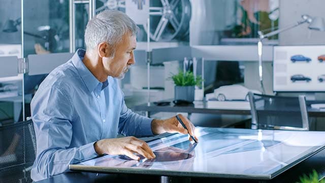 Man using large digital drawing tablet on table