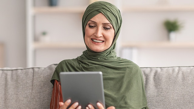 Women smiling at tablet.