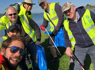 OpenText employees cleaning a beach