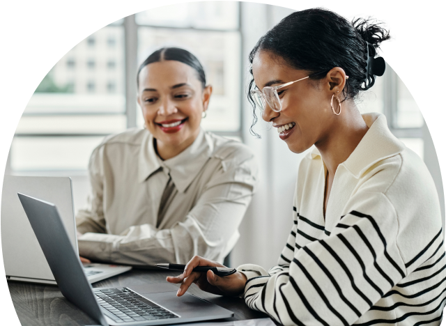 Smiling people looking at laptop while sitting in office