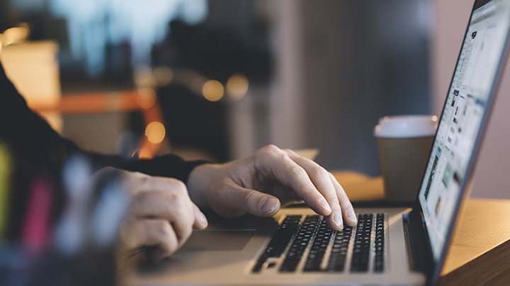 hands typing on a laptop keyword