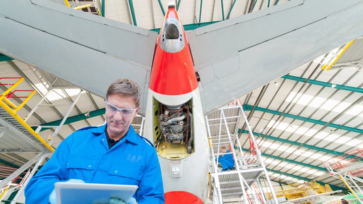 Um homem trabalha na seção da cauda de um avião