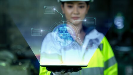 A person holding a tablet with a holographic digital interface projection