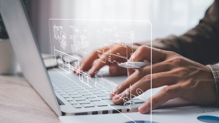 A person typing on a laptop with a digital data overlay