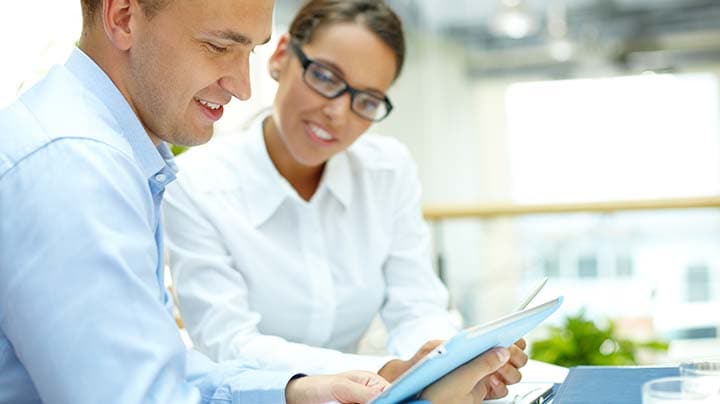 colleagues reviewing work on a tablet