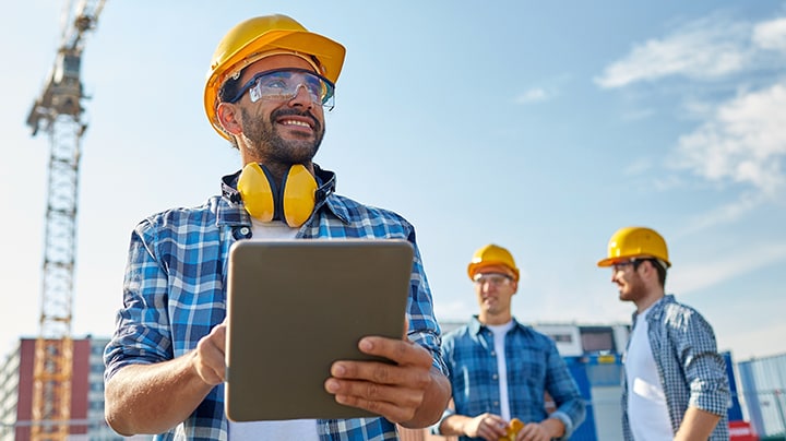 Person auf einer Baustelle, die auf ihrem Tablet Viewing and Transformation-Lösungen nutzt.