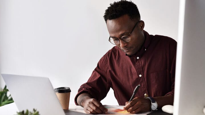 man writing in a notebook image