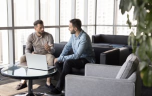 Two people sitting on couch and talking