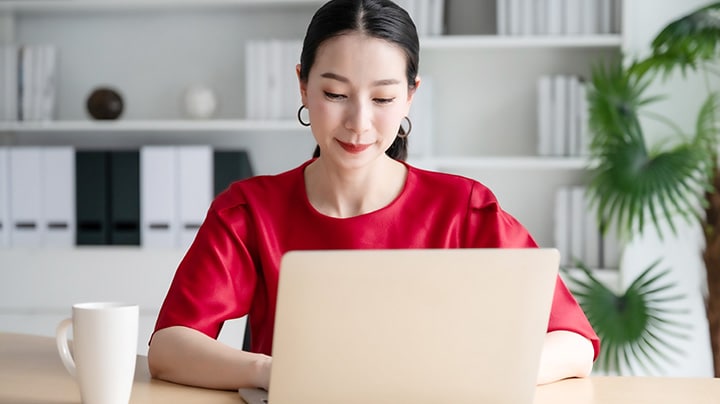 Person sitting behind laptop working on information archiving solutions.