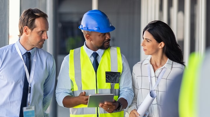 Personne sur un chantier de construction utilisant les solutions de visualisation et de transformation sur sa tablette.