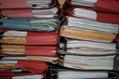 Stacks of old paper files and folders