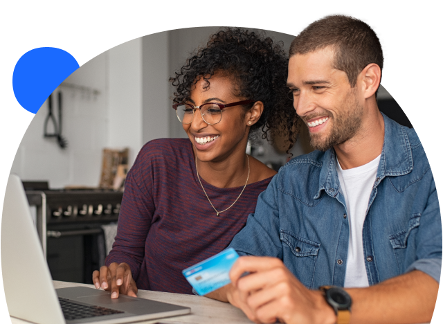 Two people looking at a laptop and holding a credit card