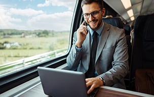 uomo che lavora su un computer portatile in un treno