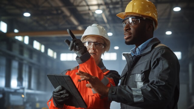 Two people discussing an issue on a manufacturing floor