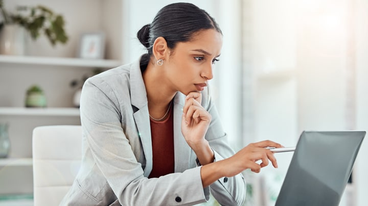 Frau schaut auf den Computerbildschirm und zeigt auf etwas