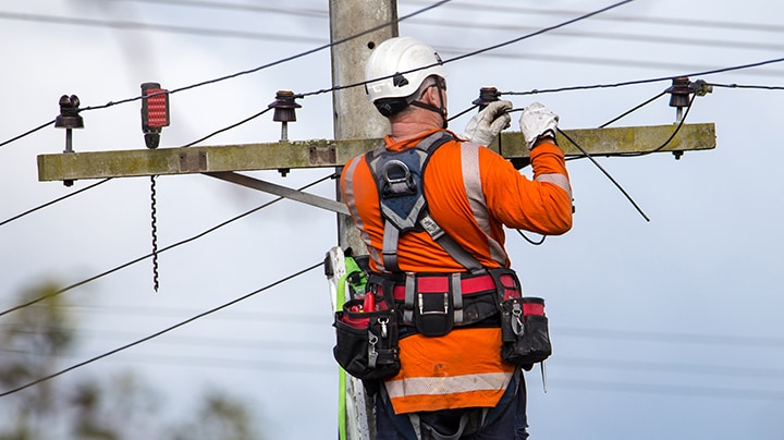 Uomo al lavoro sulla linea idroelettrica