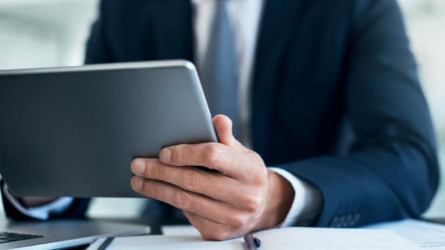 close up of a person's hands holding a tablet