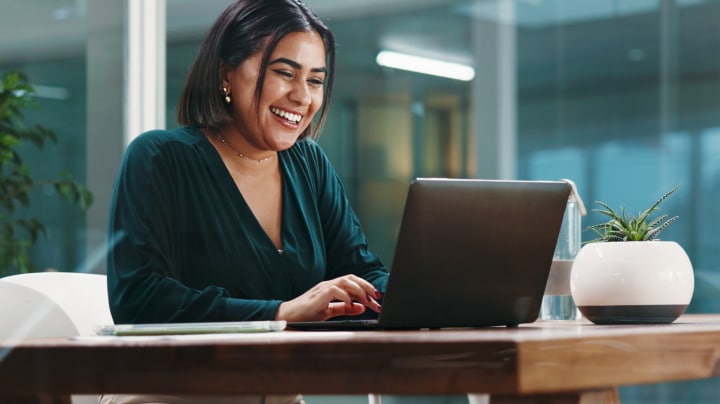 Smiling woman working on a laptop at a desk