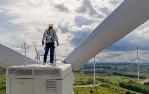 Worker standing on top of wind turbine