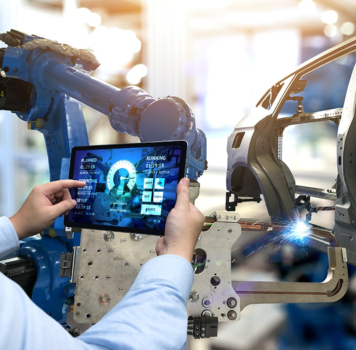 person holding tablet infront of automotive machines