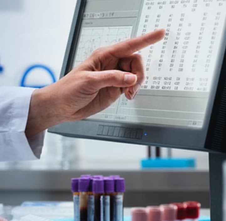 Lab technician pointing at data on a screen