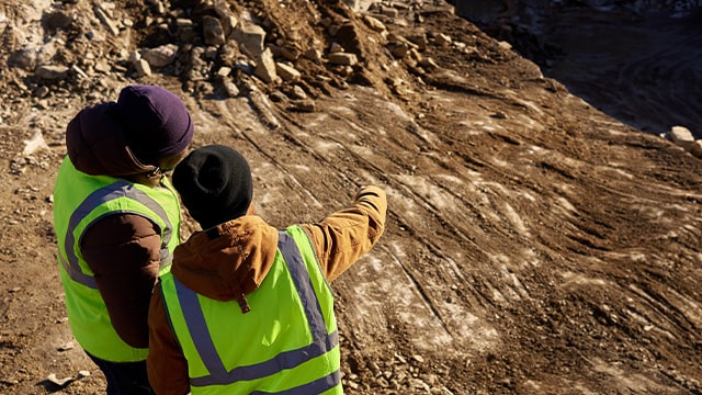 Menschen in Schutzausrüstung auf einer Baustelle.