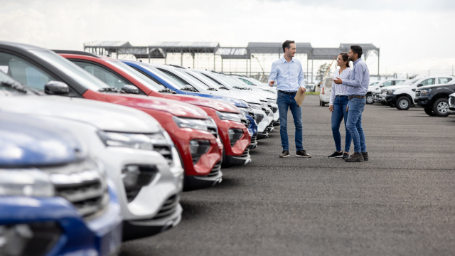 People discussing cars in a parking lot
