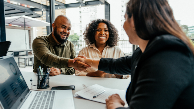 A happy couple meeting with a bank representative