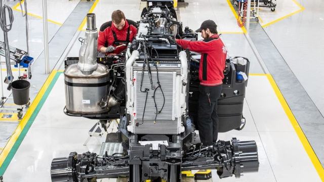 Two employees working on an engine in a factory
