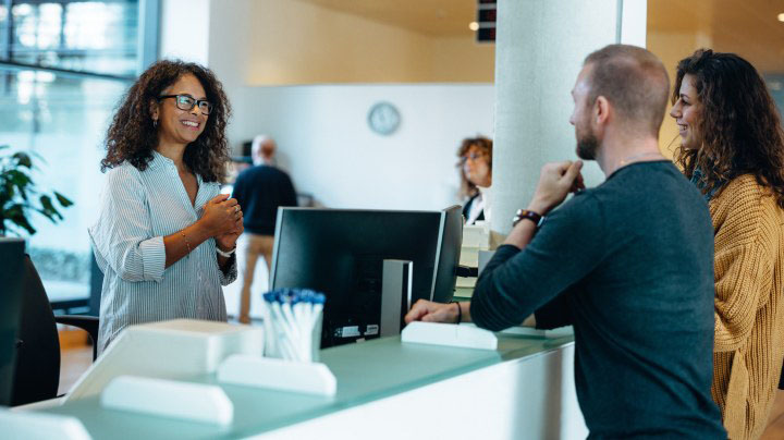Two persons talking at a reception desk in an office