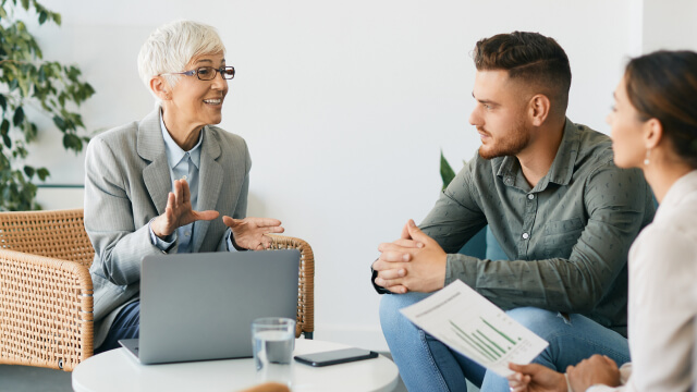 A person explaining ideas to two colleagues in a meeting