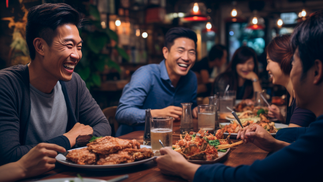 Group of friends laughing and eating together at a restaurant