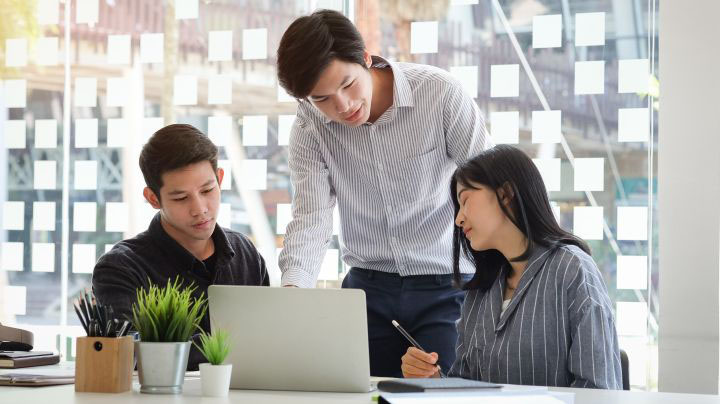 Three business people discuss at the table