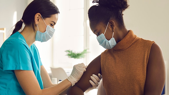 A nurse giving a needle to someone.