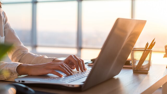 A person typing on a laptop.