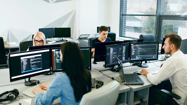 People working in an office in-front of a computer.