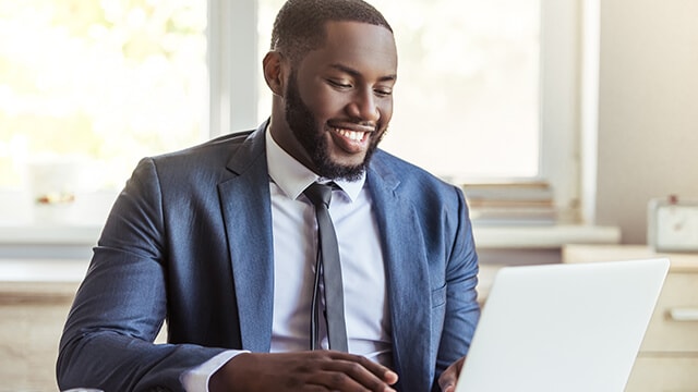 Man in a suit working at a computer.