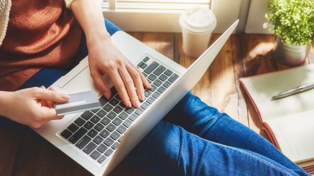 Person sitting and online shopping with laptop and credit card 
