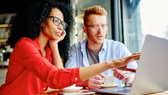 Woman and man discussing while looking at a laptop