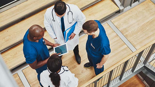 overview of medical professionals discussing a digital document.