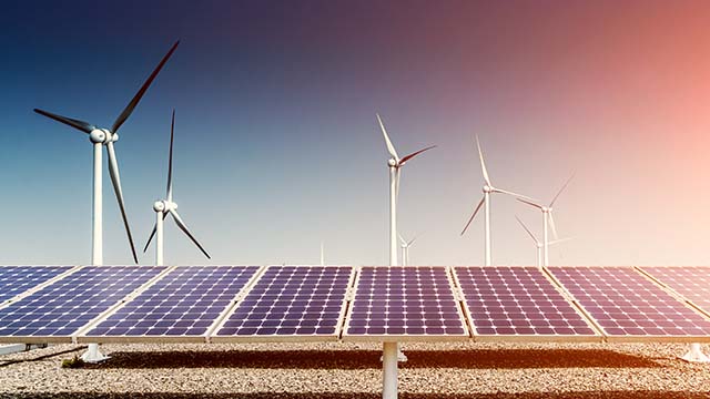 Solar panels with windfarm in the background