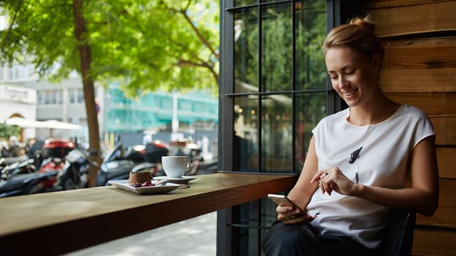 Woman using phone in coffee shop