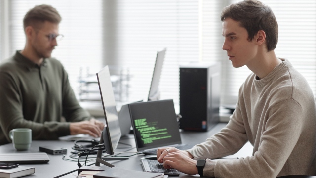 Two developers working on computers in an office