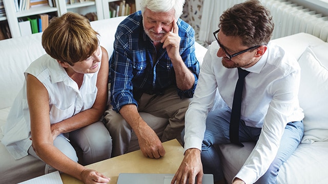 a man in a tie talking to a couple