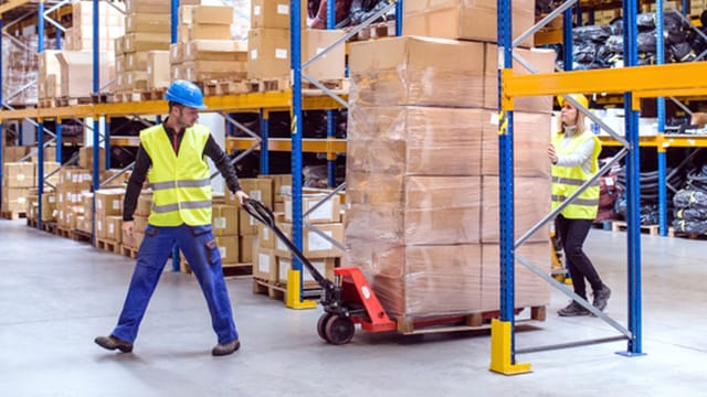 Man and women using a manual forklift.