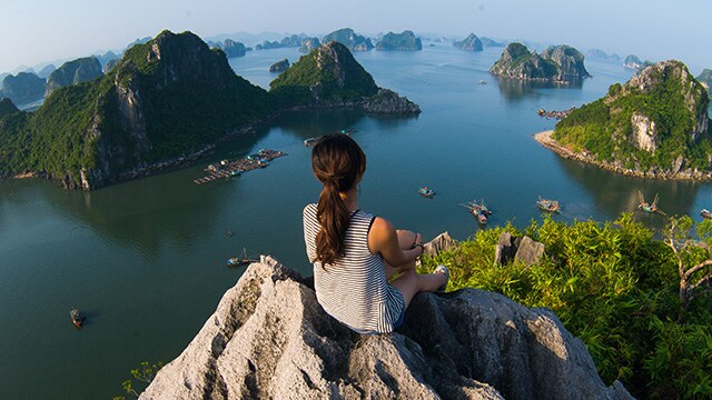 A women sitting on a cliff.