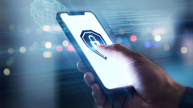 Hand using a smartphone with a digital security icon