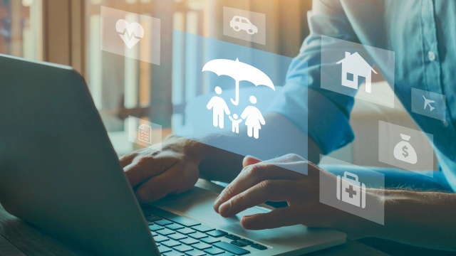 Person using a laptop with digital insurance and protection icons displayed