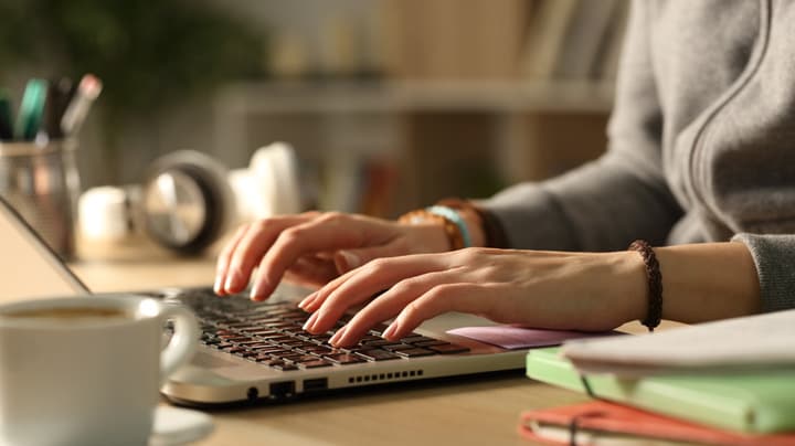 mãos digitando em um teclado de laptop