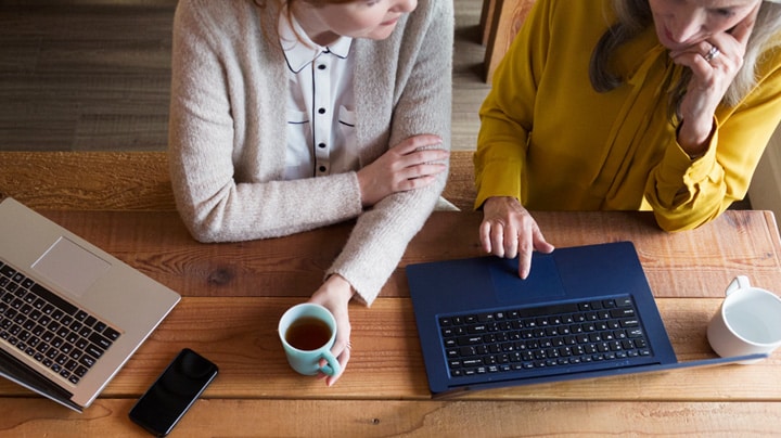 dos personas trabajando juntas en un portátil